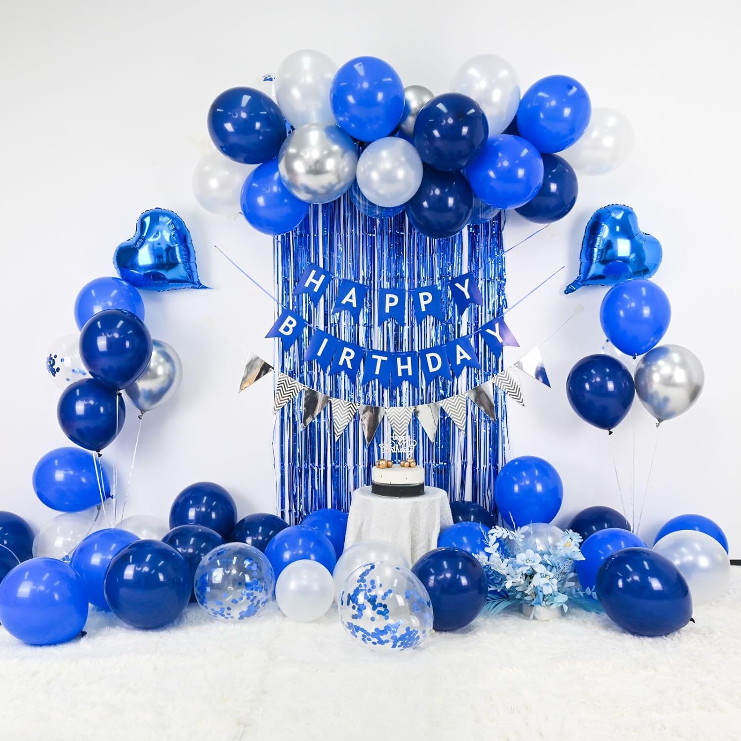 Blue and silver birthday decoration with navy blue, white balloons, and heart-shaped foil balloons for men's celebration.