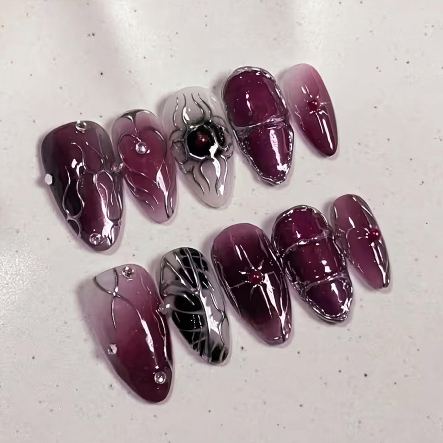 Medium almond dark purple Gothic press-on false nails with rhinestone silver star design, glossy acrylic full cover nails for women.