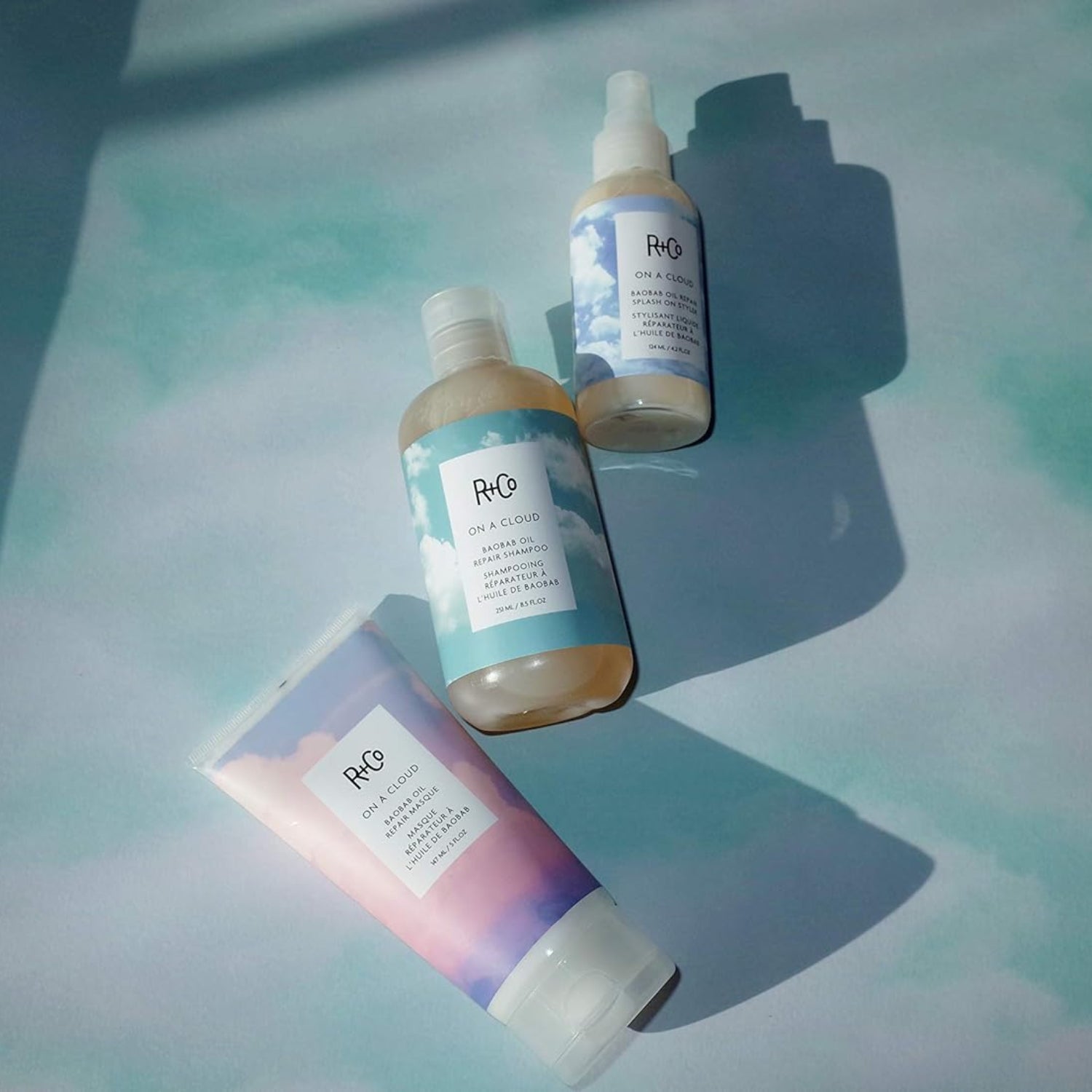 R+Co On A Cloud Baobab Oil Repair Splash On Styler bottle, 124 ml, with clear label and product packaging visible.
