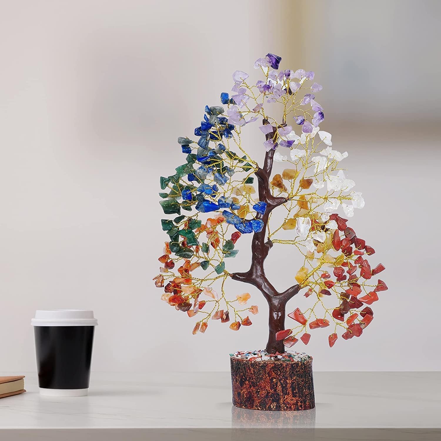 Colorful crystal tree on a white surface with a blurred background