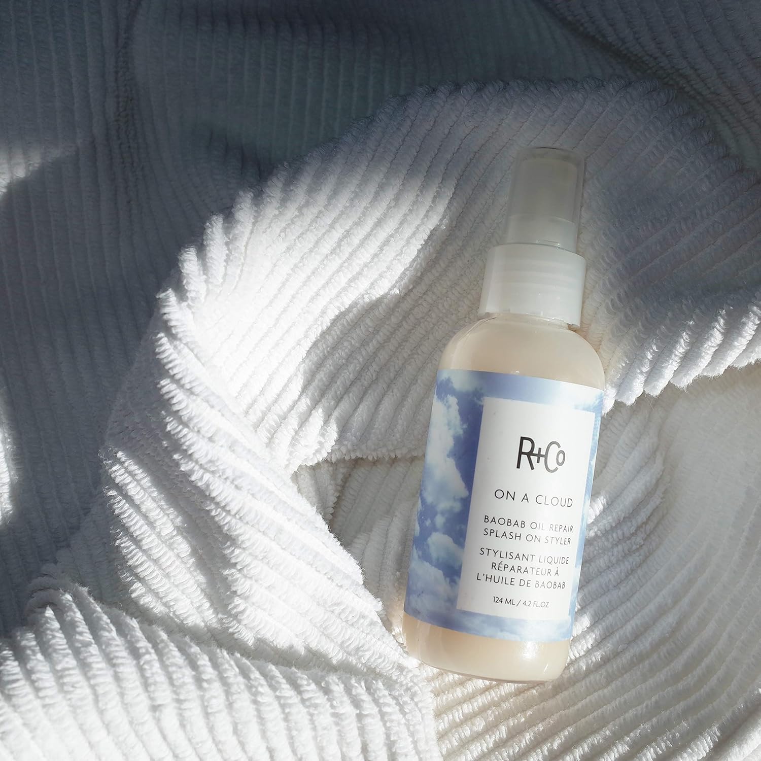 R+Co On A Cloud Baobab Oil Repair Splash on styler bottle, 124 ml, with product label and packaging details visible