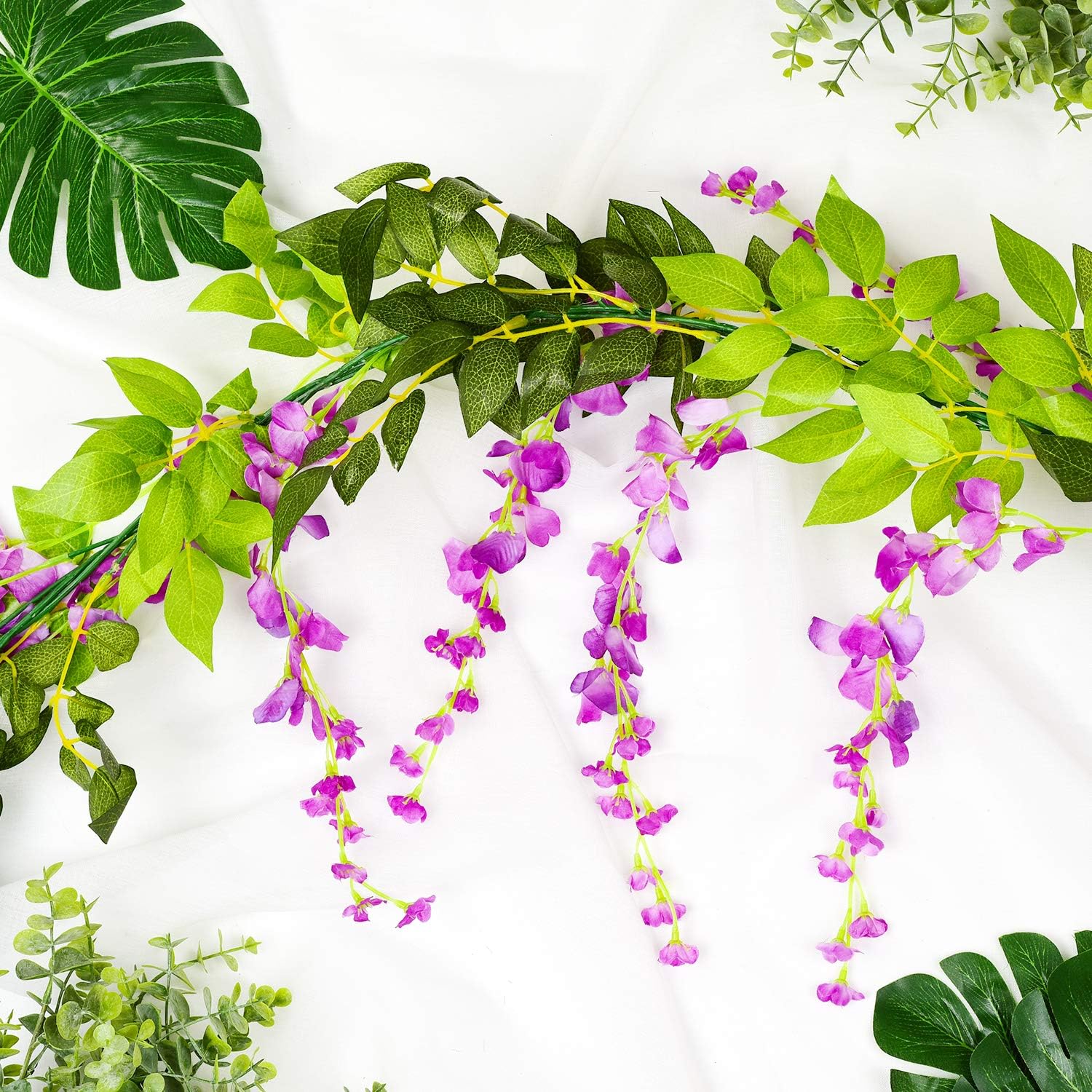 DearHouse 4-piece artificial silk wisteria garland, 6.6 feet long, with vibrant purple flowers and green leaves for decorative use.
