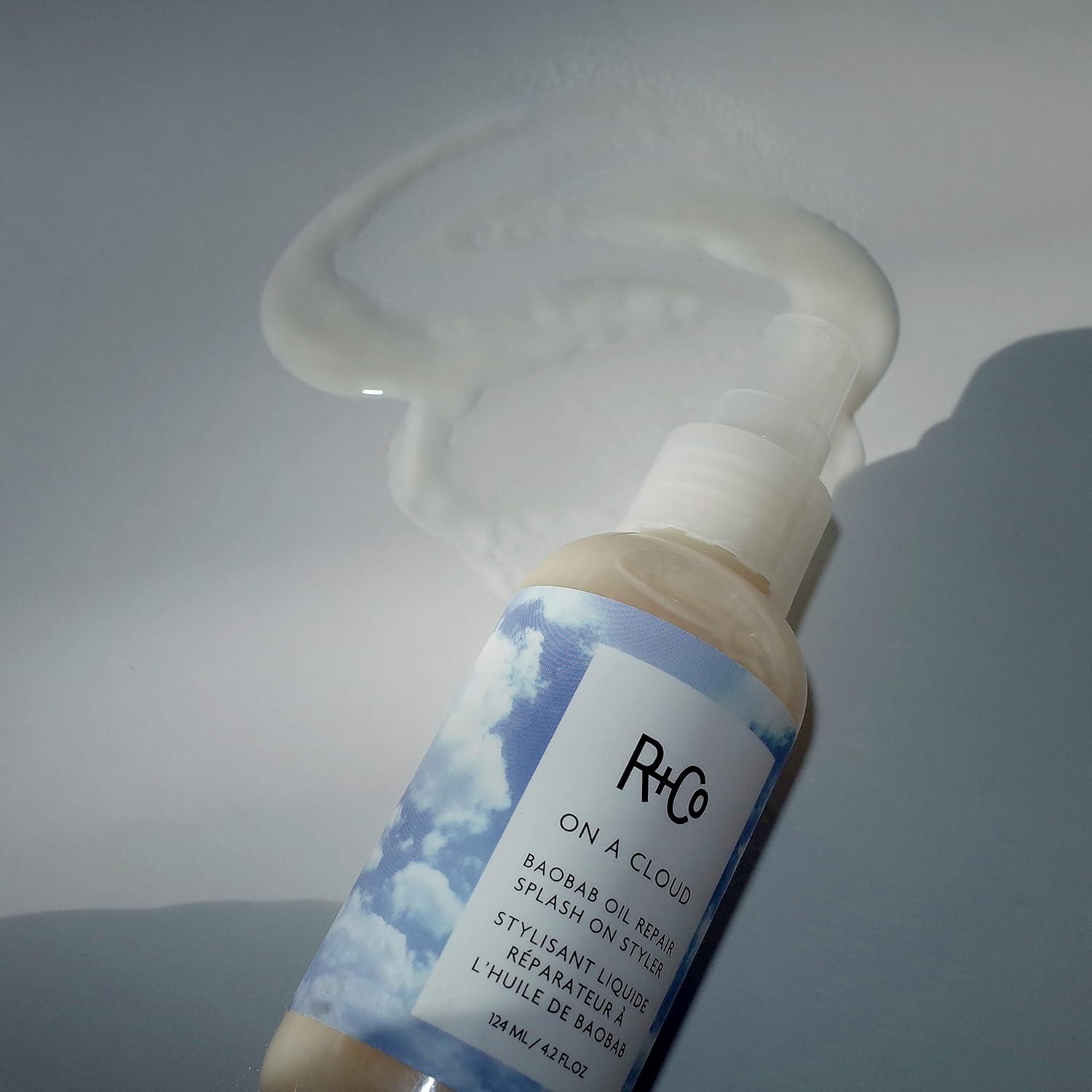 R+Co On A Cloud Baobab Oil Repair Splash on styler bottle, 124 ml, with product label and applicator cap visible
