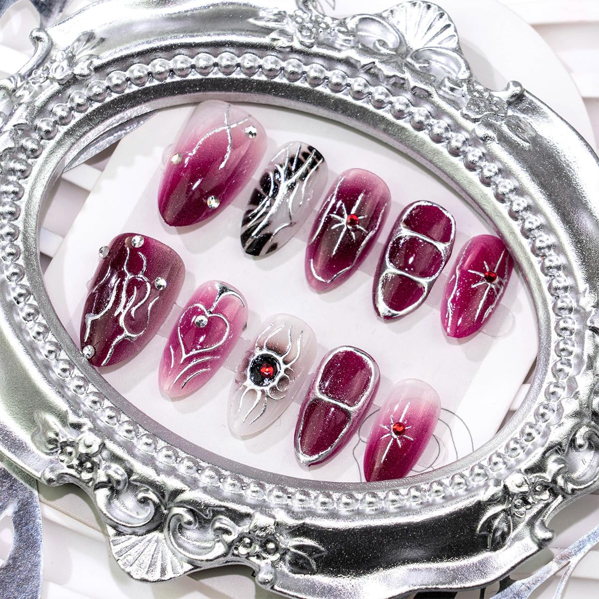 Medium almond gothic press on false nails by BUNLVDI in dark purple with silver star rhinestone design, glossy acrylic full cover set.