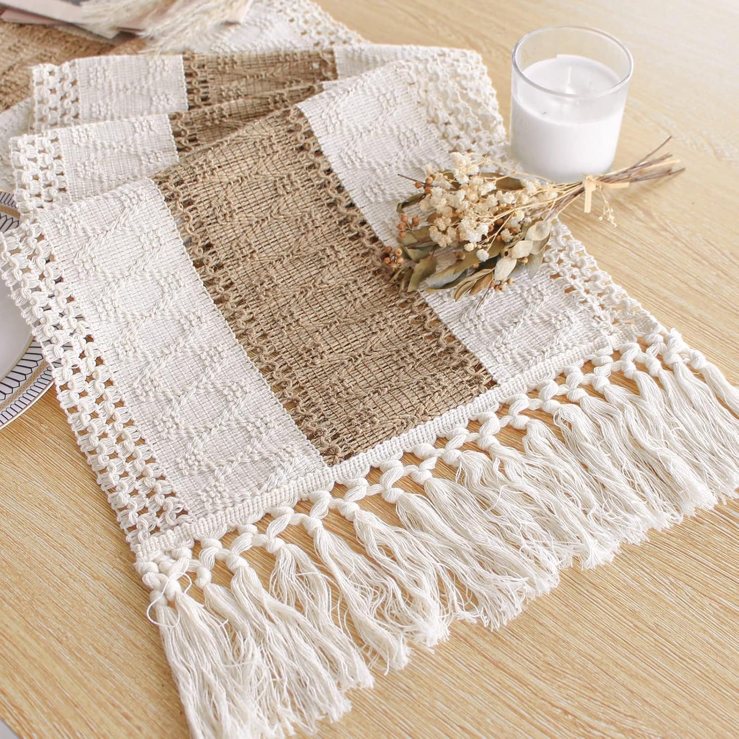 Set of woven placemats with tassels on a wooden table.