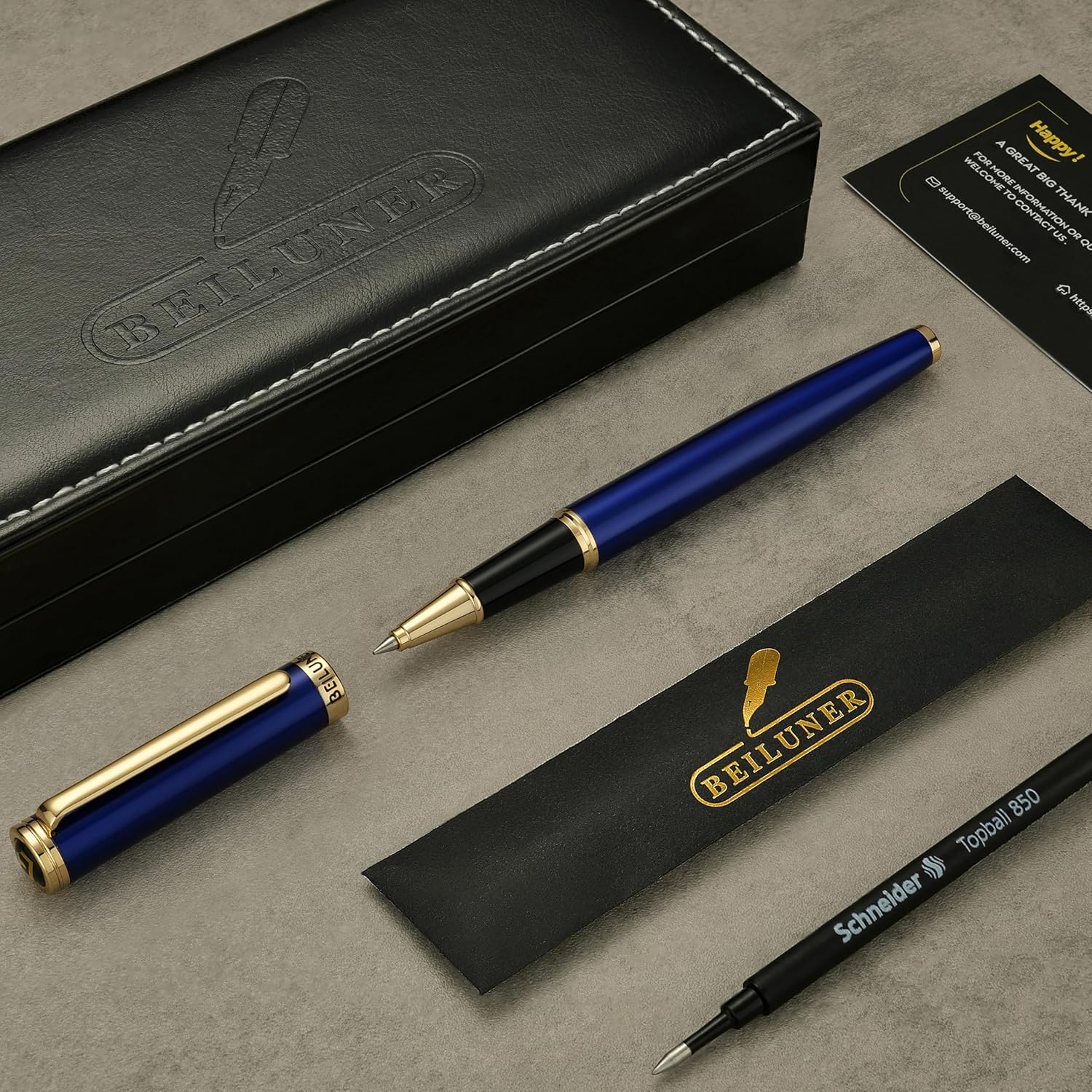Blue and gold pen with black box and Schneider pen on a gray surface