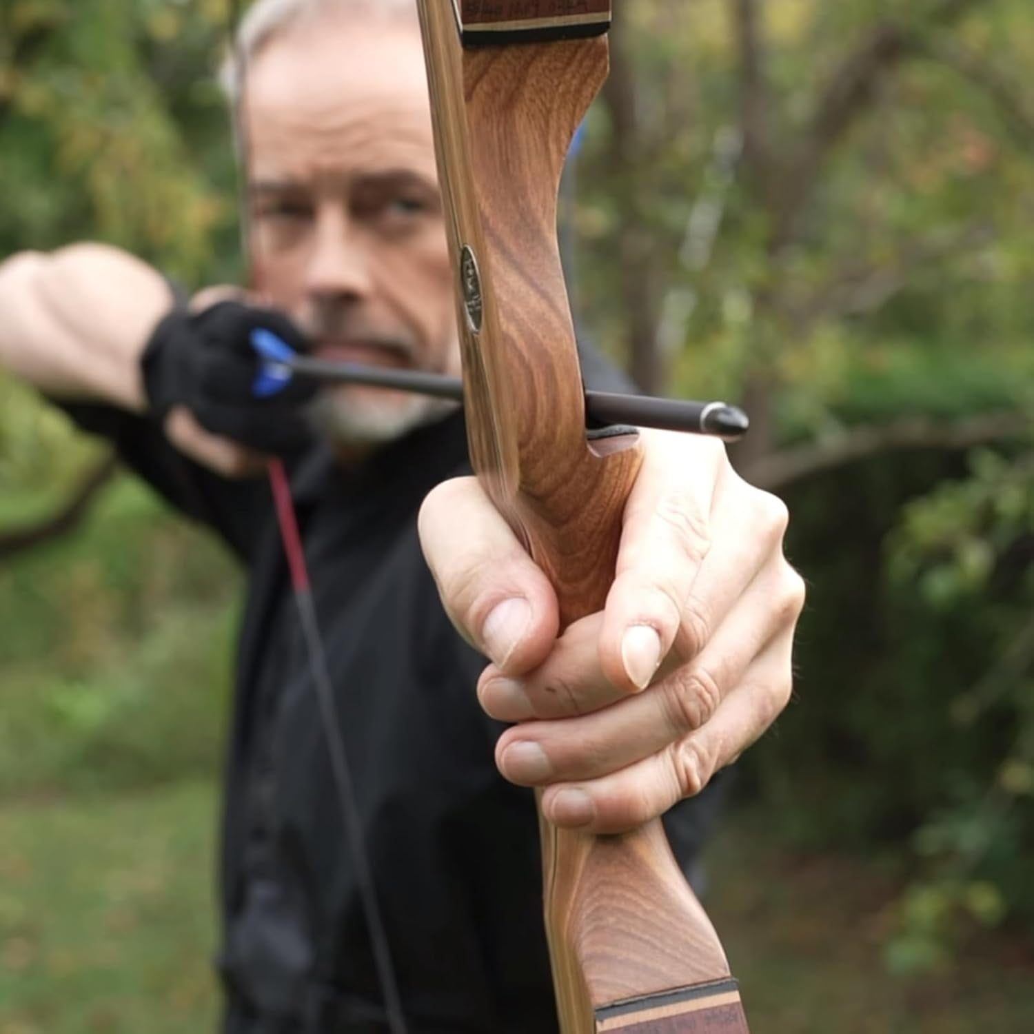 Sanlida Eagle X9 58-inch RTH recurve bow with matching arrows, showcasing the bow's wooden finish and arrow set on a plain background.